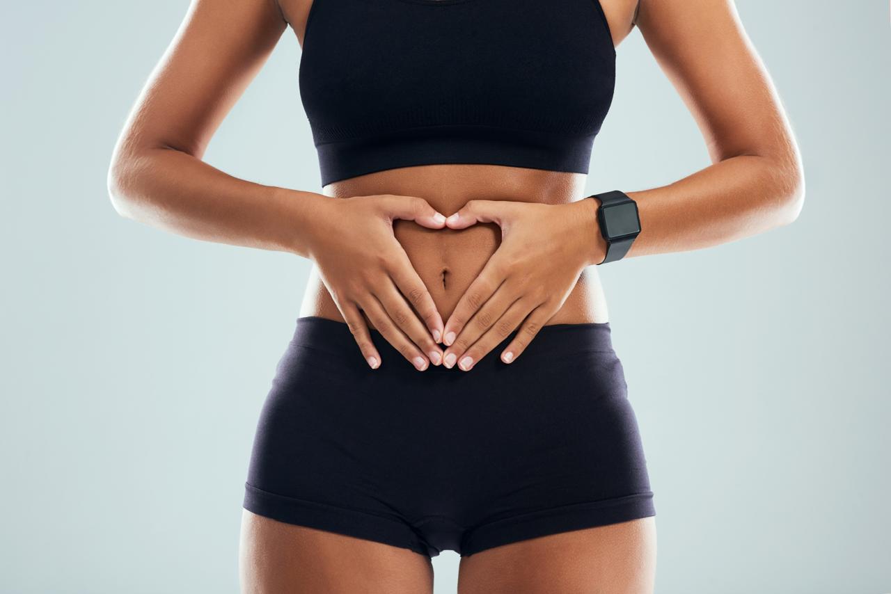 A woman forming a heart shape with her hands over her abdomen